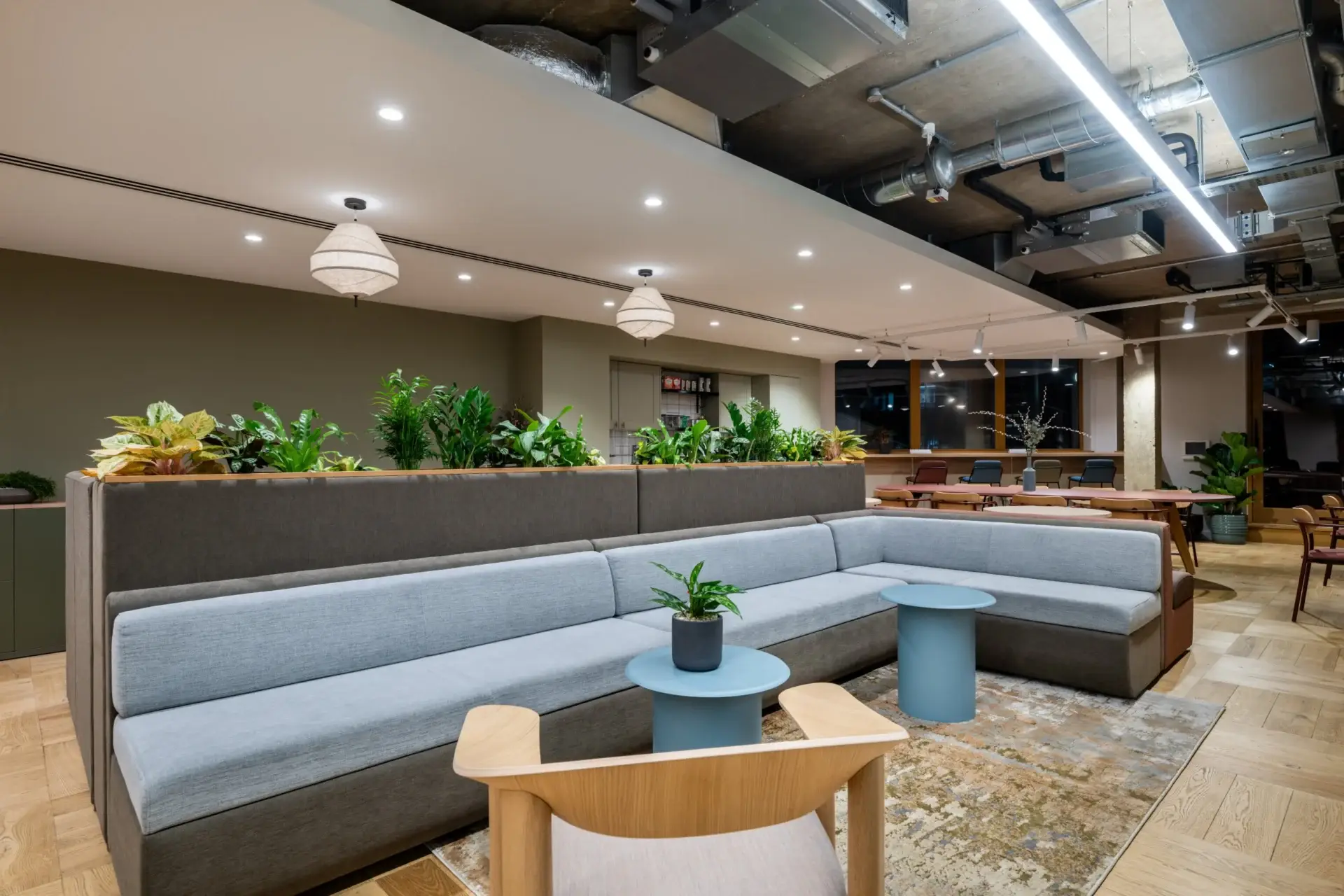 Booth seating and breakout space at Equal Experts with a sage green tea point beyond
