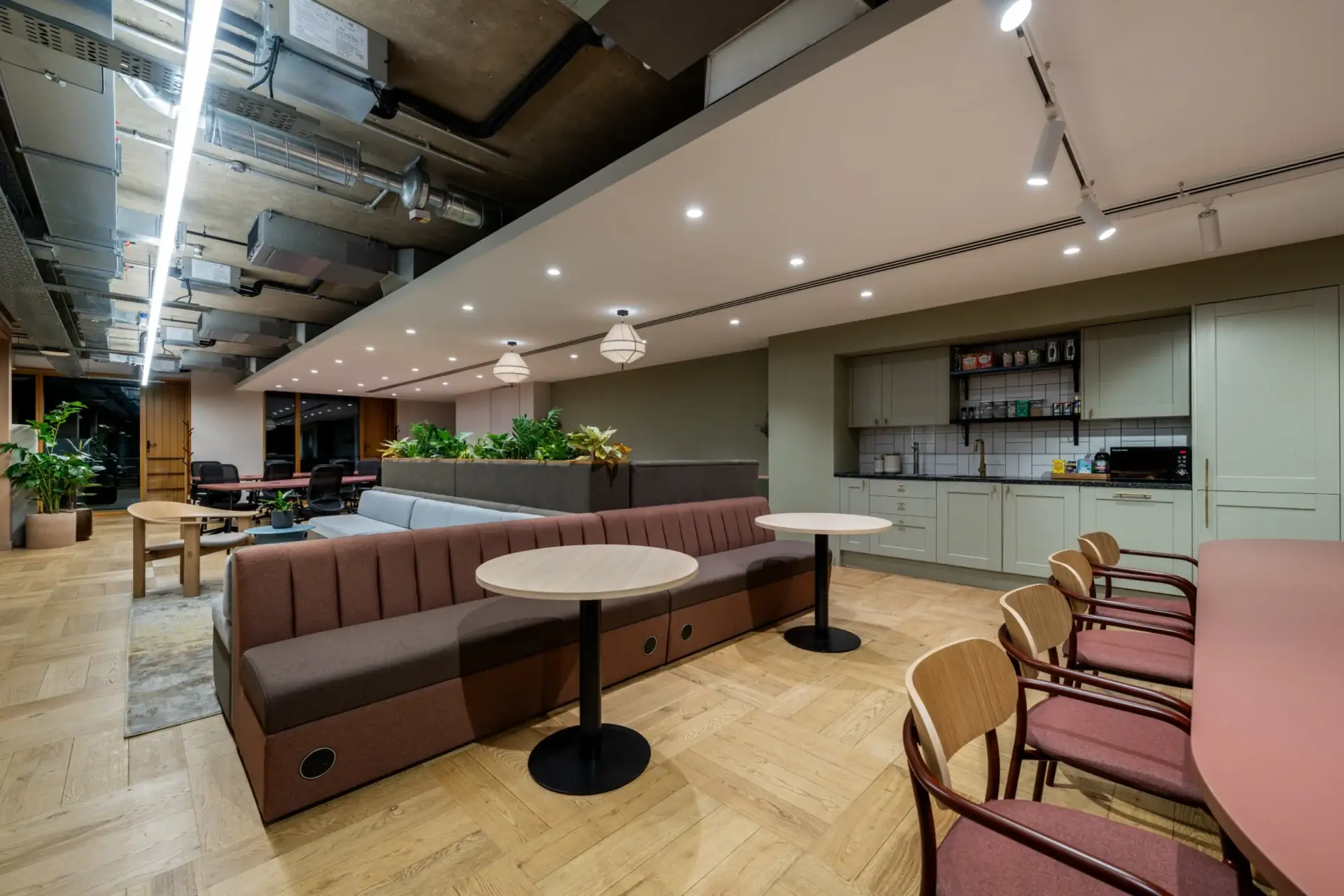 Breakout area at Equal Experts with booth seating, cafe tables and the refreshed sage green tea point
