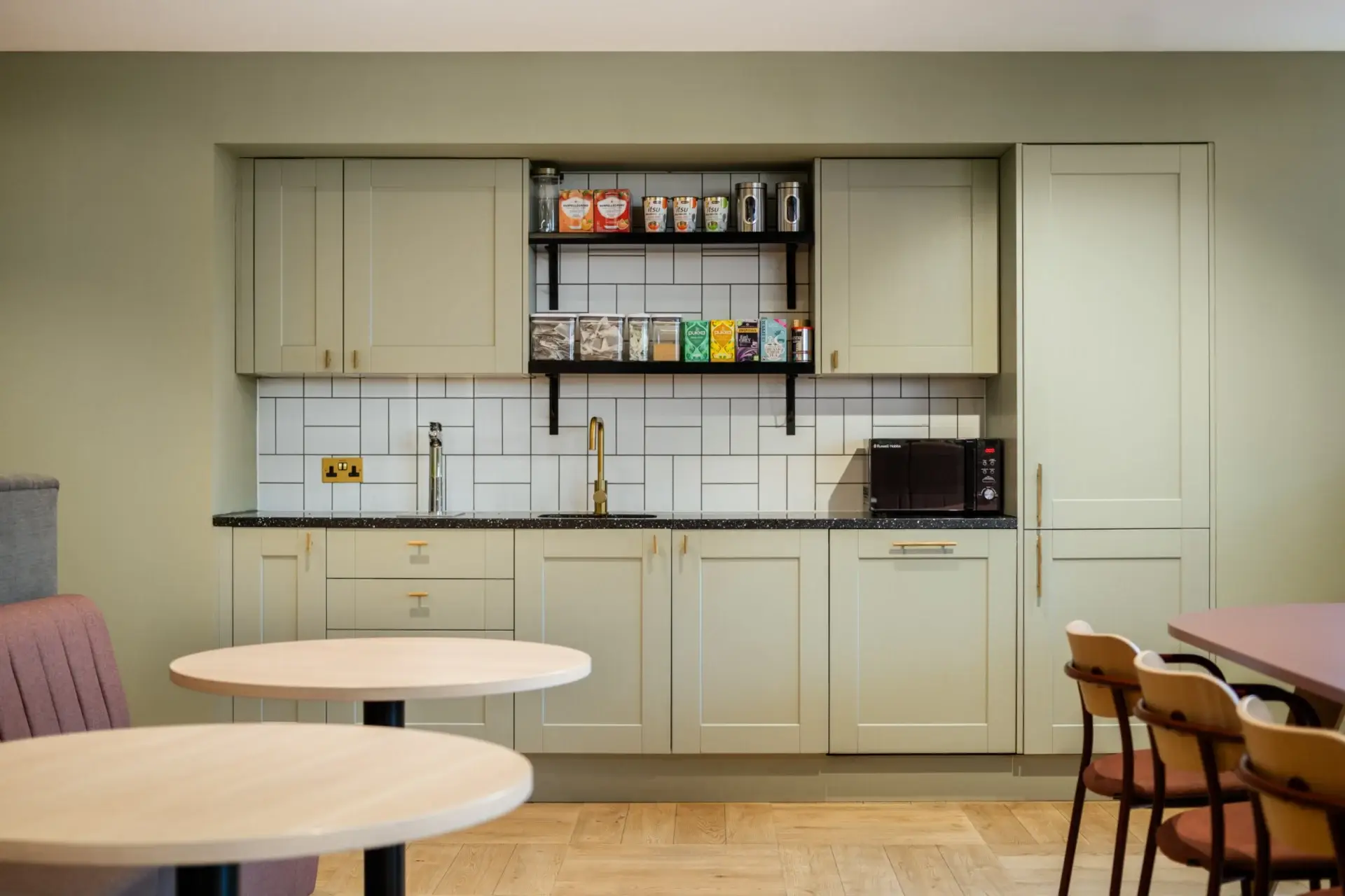 Existing tea point at Equal Experts refreshed with sage green shaker doors and brass-finish handles
