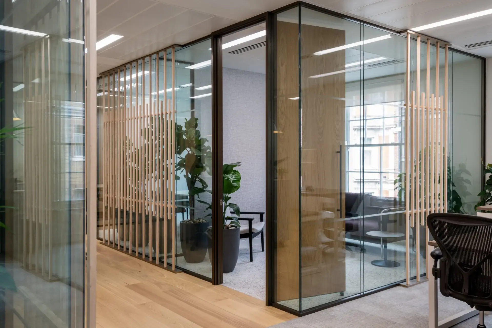 Timber veneer slat screens with bronze mid rails on the glazed meeting room fronts at Talis Capital