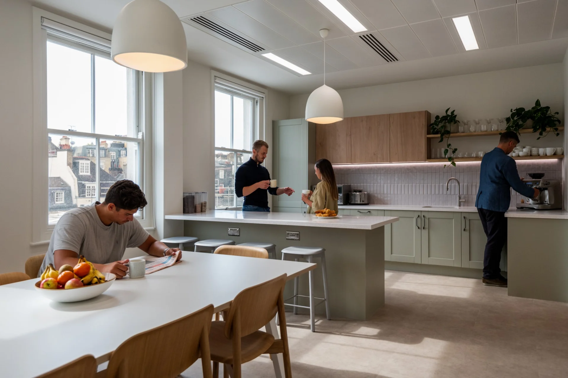 Talis Capital tea point with sage green shaker units, timber wall cupboards and an island with breakfast bar seating